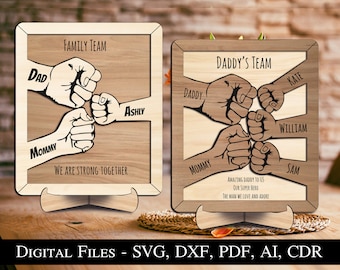 May include: Two wooden signs with a family theme. The signs feature a fist bump design with the words "Family Team" and "Daddy's Team". The signs are perfect for a father's day gift or a family gathering.