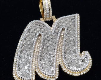May include: A gold pendant in the shape of the letter M, encrusted with baguette-cut diamonds.