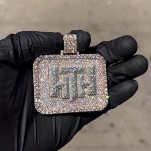 K&ouml;nnte beinhalten: Ein quadratischer Anh&auml;nger mit den Buchstaben "HT", die mit Diamanten besetzt sind und von einem ros&eacute;goldenen Rand umgeben sind.