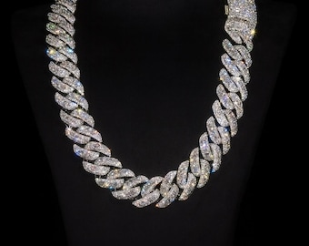 May include: A dazzling, diamond-studded necklace displayed on a black mannequin. The necklace features a thick, curb chain design, with each link covered in sparkling, clear gemstones. The jewelry is presented against a dark background, highlighting its brilliance.