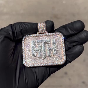 K&ouml;nnte beinhalten: Ein quadratischer Anh&auml;nger mit den Buchstaben "FTH", die mit Diamanten besetzt sind. Der Anh&auml;nger ist aus Gold gefertigt und hat eine diamantbesetzte &Ouml;se.