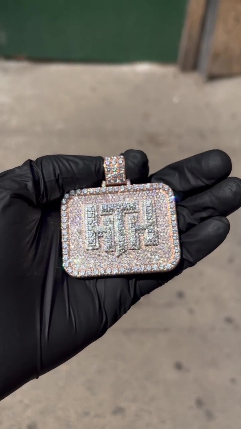 K&ouml;nnte beinhalten: Ein quadratischer Anh&auml;nger mit den Buchstaben "FTH", die mit Diamanten besetzt sind. Der Anh&auml;nger ist aus Gold gefertigt und hat eine diamantbesetzte &Ouml;se.