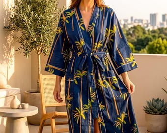 May include: A navy blue robe with a palm tree pattern. The robe has a tie waist, white trim, and long sleeves. The robe is knee-length and is worn outdoors.
