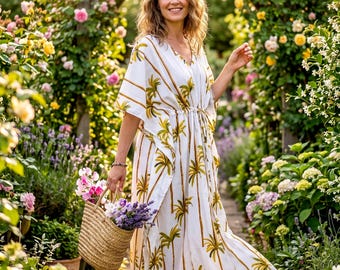May include: A white, flowing dress with a palm tree pattern and a drawstring waist. The dress is worn in a garden setting, and a straw basket filled with flowers is held in the hand. The dress is knee-length and has short sleeves.