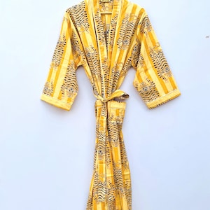 Könnte beinhalten: Eine gelbe und schwarze gestreifte Robe mit Tigermuster. Die Robe hat einen Bindegürtel und lange Ärmel.
