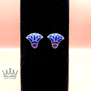 May include: A pair of silver stud earrings with a blue enamel design. The design is a stylized flower with a silver outline.