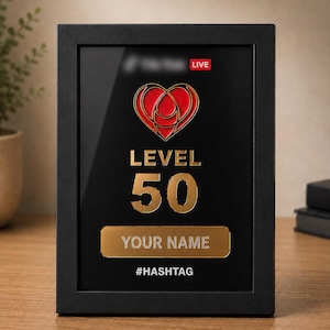 Könnte beinhalten: Eine rechteckige Plakette mit schwarzem Rahmen, die ein rotes Herzsymbol, den Text LEVEL 50, ein goldenes Namensschild mit dem Text YOUR NAME und den Text #HASHTAG am unteren Rand zeigt. Oben befindet sich ein rotes Feld mit dem Text LIVE.