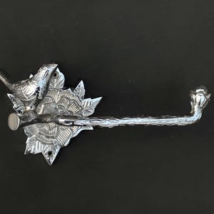 Peut inclure: Porte-papier toilette argent&eacute; avec un motif d'oiseau et de fleurs. Le porte-papier est mont&eacute; sur un mur.
