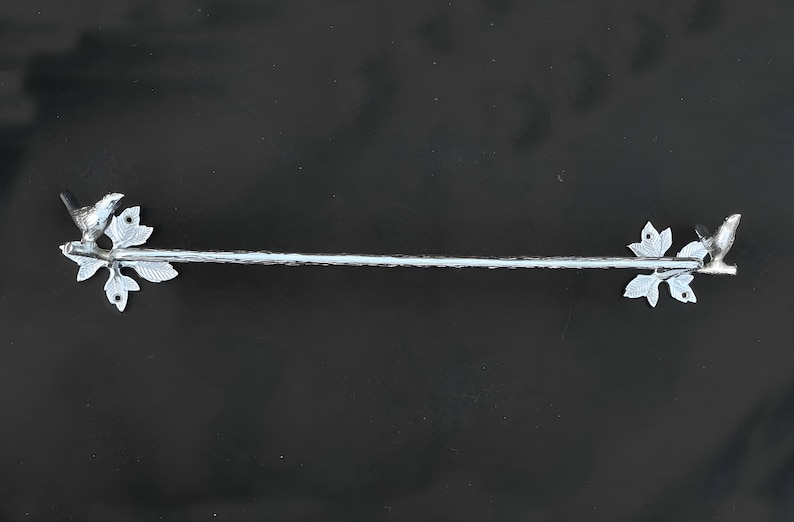 Peut inclure: Porte-serviettes en argent avec un motif d'oiseau et de feuilles &agrave; chaque extr&eacute;mit&eacute;.