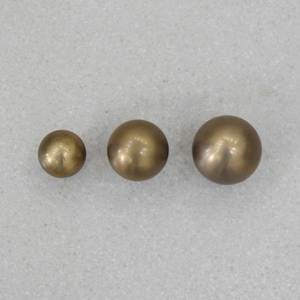 May include: Three round, metallic, gold-colored knobs of different sizes.