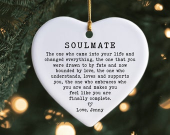 May include: White heart-shaped ceramic ornament with a gold string for hanging. The ornament has a black inscription that reads "SOULMATE The one who came into your life and changed everything, the one that you were drawn to by fate and now bounded by love, the one who understands, loves and supports you, the one who embraces who you are and makes you feel like you are finally complete. ♡ Love, Jenny"