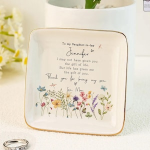 May include: A white ceramic mug with a black handle and the text "But First, Coffee" in a black, bold font. The mug is on a white surface. The mug is approximately 4 inches tall.