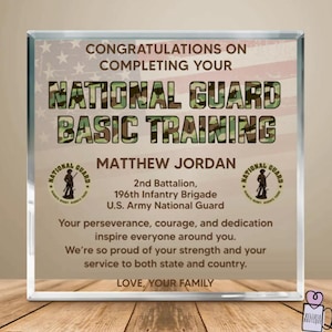 May include: A clear, rectangular plaque with text congratulating someone on completing National Guard Basic Training. The text includes the name Matthew Jordan, unit information, and a message from family. The background has a faded American flag.