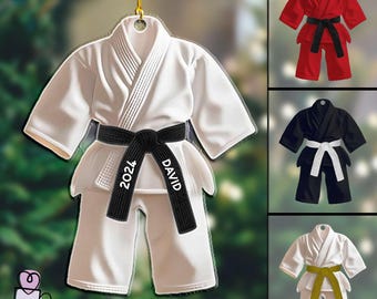 May include: White karate uniform Christmas ornament with a black belt and the name "DAVID 2021" printed on it.