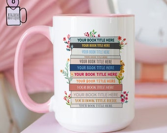 May include: White ceramic mug with a pink rim and handle. The mug features a stack of colourful books with floral illustrations and the text "YOUR BOOK TITLE HERE" repeated on each book.