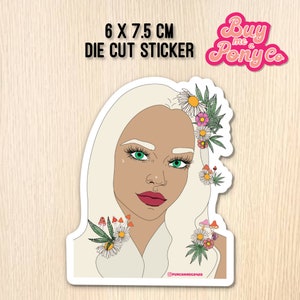 May include: A die-cut sticker featuring a white-haired woman with green eyes and red lips. She is adorned with flowers and greenery, including daisies, pink flowers, and green leaves. The sticker is 6 x 7.5 cm and has the text "Buy me a Pony Co." in the top right corner.