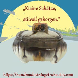Könnte beinhalten: Ein Vintage-Keramiktopf mit Deckel, brauner und cremefarbener Glasur. Der Topf hat eine runde Form mit Deckel und drei kleinen Füßen. Der Text auf dem Bild lautet "Kleine Schätze, stilvoll geborgen." und die Etsy-Shop-URL.