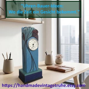 Puede incluir: Un reloj azul y verde azulado de estilo Art Déco con una esfera blanca. El reloj tiene forma rectangular con diseños florales y de hojas. El texto "Uhren-Bauer-Ideen: Wo die Zeit ein Gesicht bekommt." está encima del reloj. La URL de la tienda Etsy está en la parte inferior.