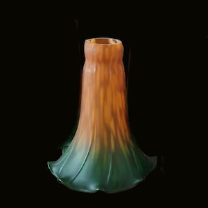 Peut inclure: Un abat-jour en verre en forme de cloche présentant un dégradé de couleur allant d'un orange ambré chaud au sommet à un vert forêt profond à la base évasée et festonnée. La surface a une finition mate lisse et un aspect translucide.
