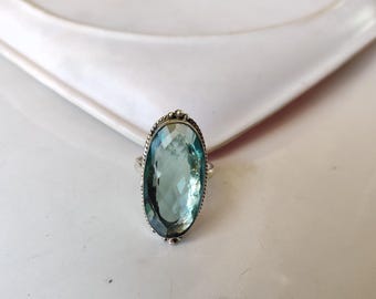 Könnte beinhalten: Ein silberner Ring mit einem großen ovalen blauen Edelstein.