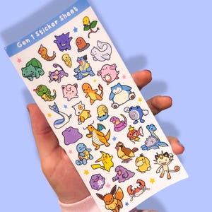 May include: A sticker sheet featuring colorful cartoon illustrations of various characters. The sheet is labeled "Gen 1 Sticker Sheet" in blue text. The stickers are of different shapes and sizes, with a variety of colors and designs.