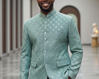 May include: A light teal jacket with a mandarin collar and a subtle floral pattern. The jacket has a button-up front and two front pockets. The person is wearing black pants.