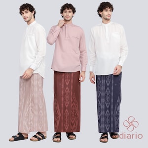 Może przedstawiać: Trzech mężczyzn w koszulach z długimi rękawami i wzorzystych sarongach. Koszule są białe, różowe i białe. Sarongi są różowe, czerwone i niebieskie.