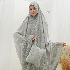May include: A light grey prayer garment set with floral lace detailing. The set includes a head covering, a long flowing garment, and a matching small pouch. The garment has wide sleeves and a delicate lace trim. The brand name "AFSHA" is visible.