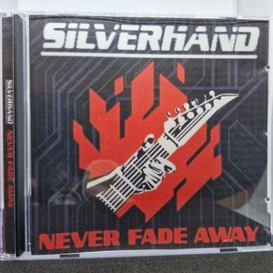 May include: A CD case with a black and red design. The front of the case features the band name "SILVERHAND" in white letters and the album title "NEVER FADE AWAY" in white letters. The band's name is also printed on the spine of the case.