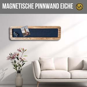 Könnte beinhalten: Eine rechteckige magnetische Pinnwand aus Holz mit einem dunkelblauen Stoffeinsatz. Die Pinnwand hat einen hellen Holzrahmen und enthält eine Postkarte und mehrere kleine Magnete. Der Text "MAGNETISCHE PINNWAND EICHE" steht oben.