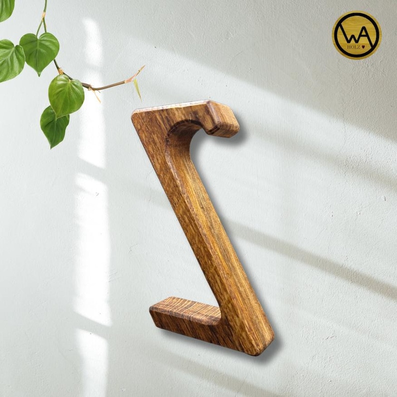 May include: A wooden wall-mounted shelf shaped like the letter 'Z'. The shelf is made of natural wood with a dark brown stain.