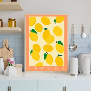 May include: A digital print of lemons with green leaves on a light peach background. The print has the word "LEMONS" in black text at the bottom.