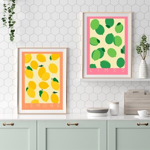 May include: Two framed prints with a white background and a yellow and green pattern of lemons and limes. The top print says "LIMES" and the bottom print says "LEMONS".
