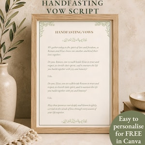 May include: A framed handfasting vow script printed on off-white paper with green floral corner accents. The text reads: Handfasting Vows, We gather today in the spirit of love and freedom, as Rowan and Elias choose one another and bind their lives together.