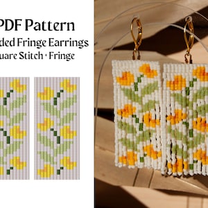 May include: PDF pattern for beaded fringe earrings with a floral design. The earrings are made with white, green, and yellow beads. The pattern includes instructions for square stitch and fringe.