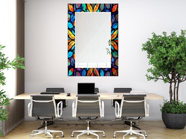 Peut inclure: Un miroir rectangulaire avec un cadre en vitrail color&eacute; pr&eacute;sentant un motif de feuilles dans des tons de bleu, vert, orange, jaune et violet. Le miroir est accroch&eacute; &agrave; un mur blanc dans un environnement de bureau.