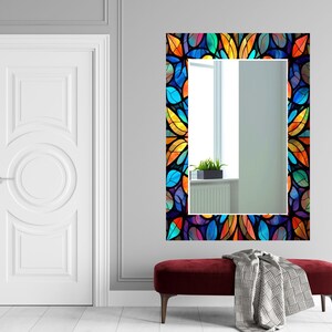 Peut inclure: Un miroir rectangulaire avec un motif de vitrail color&eacute; repr&eacute;sentant des feuilles bleues, vertes, jaunes et orange. Le miroir est encadr&eacute; d'une bordure noire.