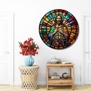 May include: A round stained glass window depicting Jesus Christ with a colorful background. The stained glass is in shades of red, orange, yellow, green, blue, and purple.