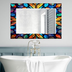 Peut inclure: Un miroir de salle de bain avec un cadre en vitrail color&eacute; pr&eacute;sentant un motif g&eacute;om&eacute;trique de feuilles dans des tons de bleu, vert, orange et jaune.
