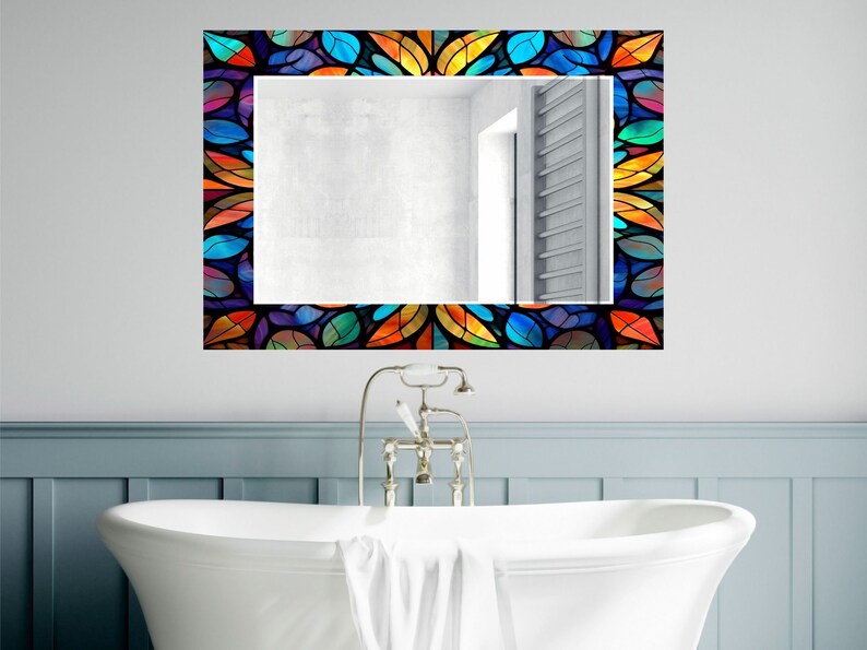 Peut inclure: Un miroir de salle de bain avec un cadre en vitrail color&eacute; pr&eacute;sentant un motif g&eacute;om&eacute;trique de feuilles dans des tons de bleu, vert, orange et jaune.