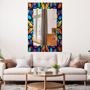 Peut inclure: Un miroir rectangulaire avec un motif de vitrail color&eacute; repr&eacute;sentant un motif r&eacute;p&eacute;titif de feuilles dans des tons de bleu, vert, jaune, orange et rouge. Le miroir est encadr&eacute; de noir.