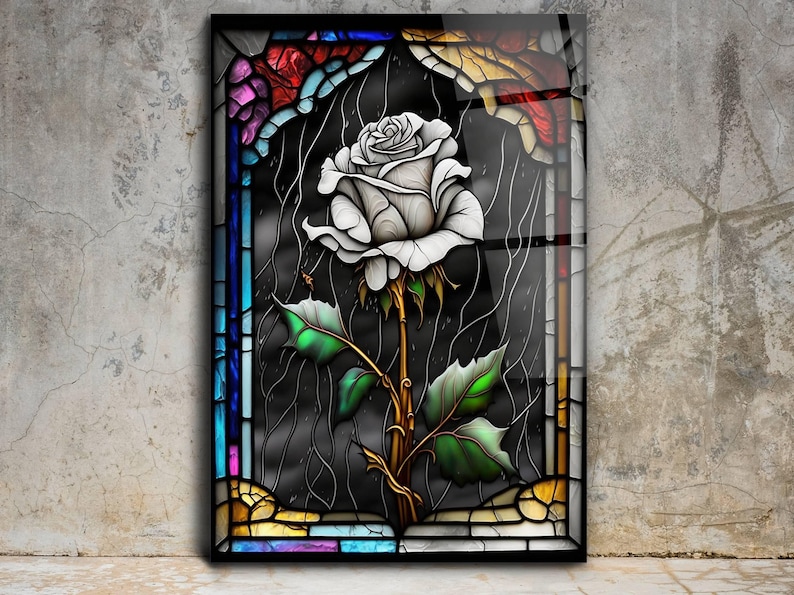 May include: A white rose with green leaves and a gold stem is depicted in a stained glass window. The window is framed with colorful glass pieces in shades of blue, red, yellow, and purple.