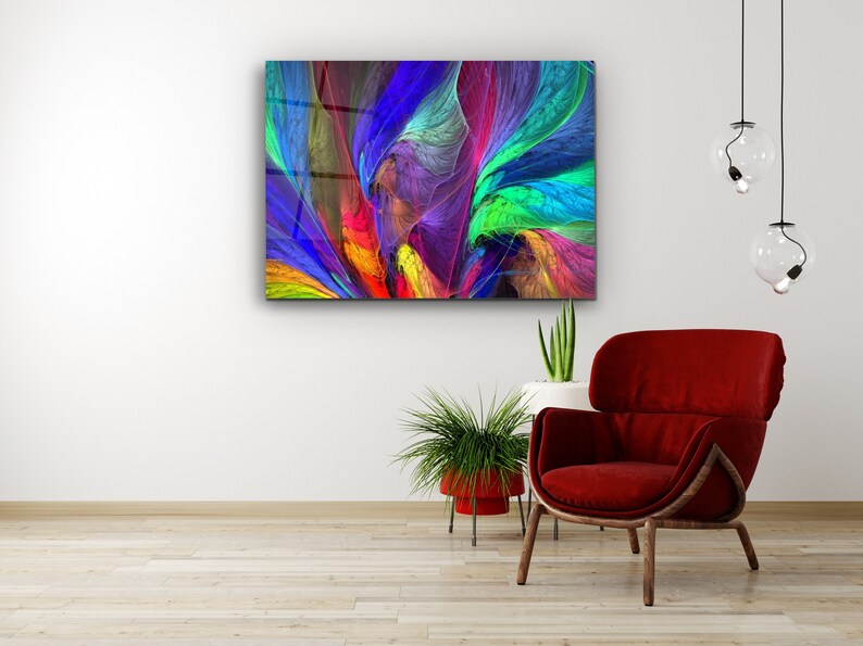 Puede incluir: Impresi&oacute;n de arte abstracto con colores vibrantes, con l&iacute;neas y formas que se arremolinan en tonos de azul, verde, amarillo, rojo y morado. La impresi&oacute;n se muestra en una pared blanca sobre un sill&oacute;n rojo y una planta en maceta.