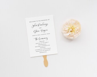 May include: A white wedding programme fan with black text. The text reads "Welcome to the wedding of Julia Rawlings and Steven Wagner June 30, 2022 | Houston, Texas The Ceremony Prelude Seating of the Family Processional Welcome & Introduction Readings Exchange of Vows & Rings Pronounce of Marriage Recessional"