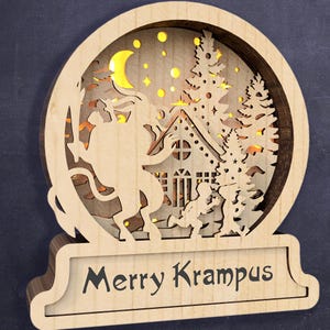 May include: A wooden Christmas decoration with a cut-out design of a Krampus figure riding a goat, a house, and trees. The decoration has a light inside and the words "Merry Krampus" on the base.