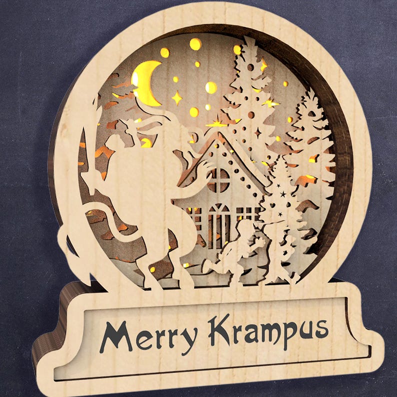May include: A wooden Christmas decoration with a cut-out design of a Krampus figure riding a goat, a house, and trees. The decoration has a light inside and the words "Merry Krampus" on the base.