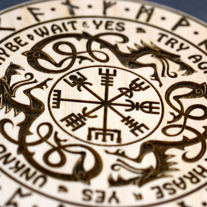 May include: A wooden circle with a compass design in the center. The compass is surrounded by four stylized dragons, each with a different rune on its back. The runes are "F", "Y", "P", and "K". The circle is inscribed with the words "Try Again", "Wait", "Yes", "Unking", "Try", "Yes", "Wait", "Try Again", and "Unking".