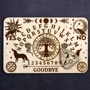 K&ouml;nnte beinhalten: Holz-Ouija-Brett mit Planchette, einem Lebensbaum-Design und den Buchstaben des Alphabets, den Zahlen 1-9 und den W&ouml;rtern "YES", "NO" und "GOODBYE".
