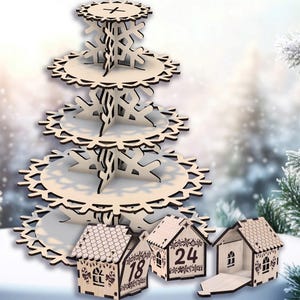 May include: A wooden tiered serving stand with snowflake cutouts and three small wooden house-shaped advent calendar boxes. The stand has four tiers and is made of light-colored wood. The houses have numbers and decorative details.