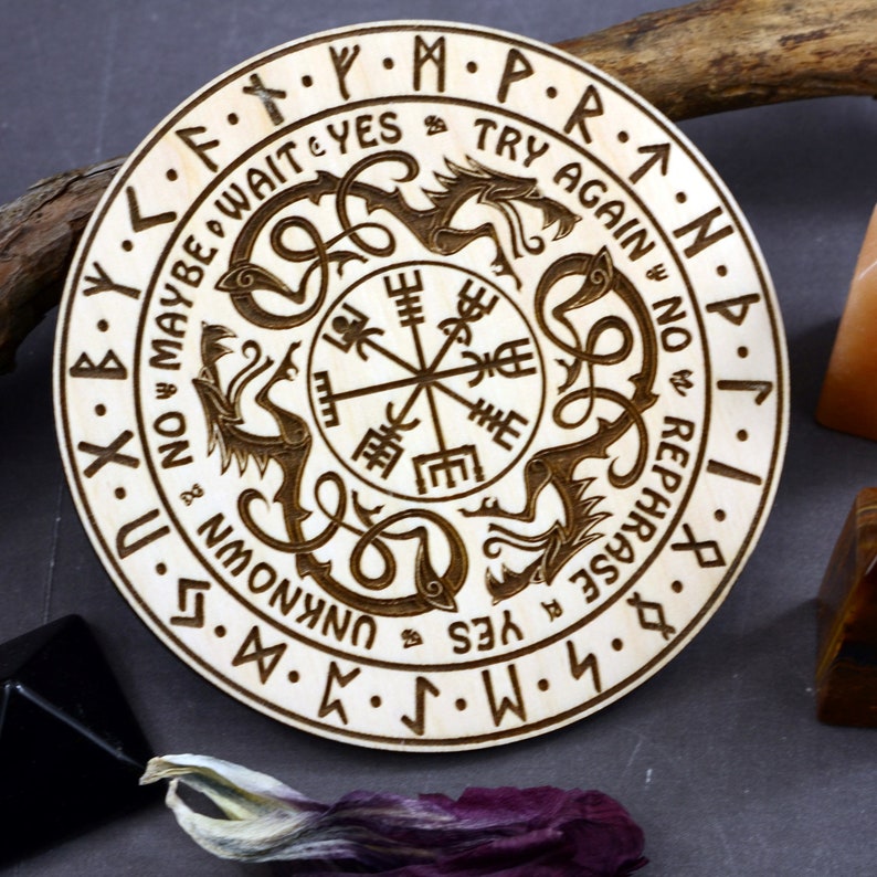 May include: A wooden circular divination board with a compass in the center and two dragons surrounding it. The board is inscribed with runes and the words "Maybe Wait Yes Try Again No Rephrase Yes Unknown".